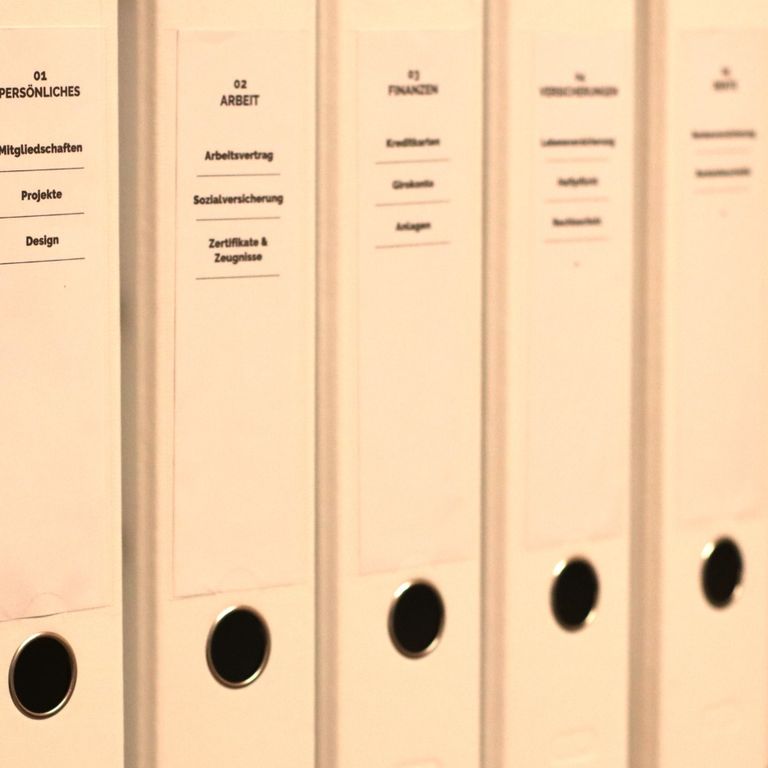 Einheitlich beschriftete weiße Aktenordner für Persönliches, Arbeit, Finanzen und Versicherungen